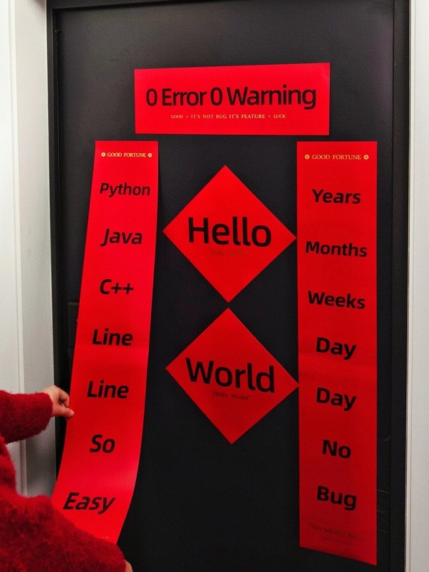 Red posters on a door displaying programming languages and phrases like 'Hello World' and 'No Bug' with a playful design.