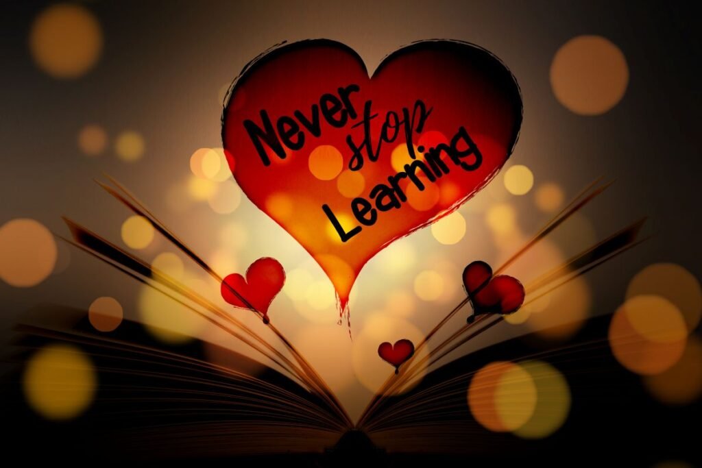 一本打开的书页上方漂浮着写有“Never stop learning”的红色爱心，周围点缀暖色光斑，呼应从零开始用WordPress建立自己的知识变现平台。